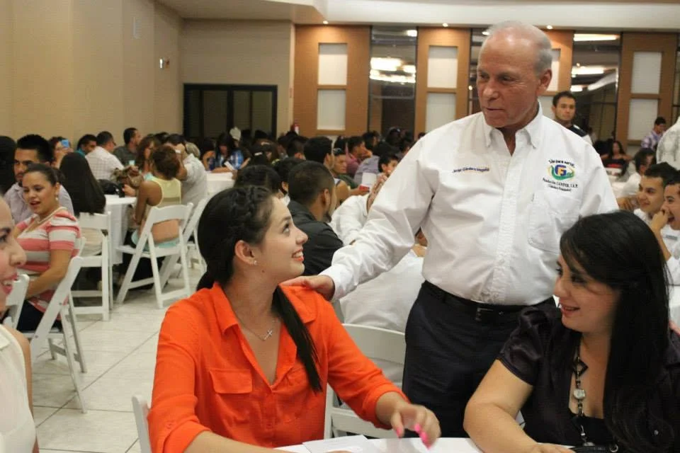 Javier Gándara Magaña conversa con asistentes durante un encuentro con jóvenes en un evento público.