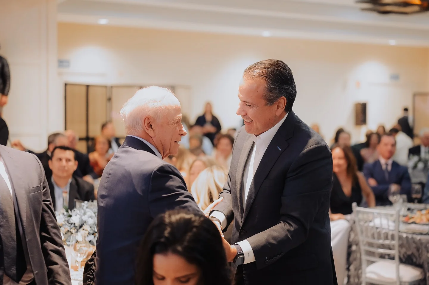 Javier Gándara Magaña siendo felicitado por asistentes en un evento