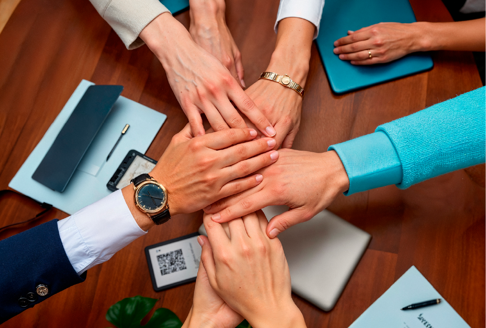 Grupo de profesionales uniendo las manos en señal de trabajo en equipo