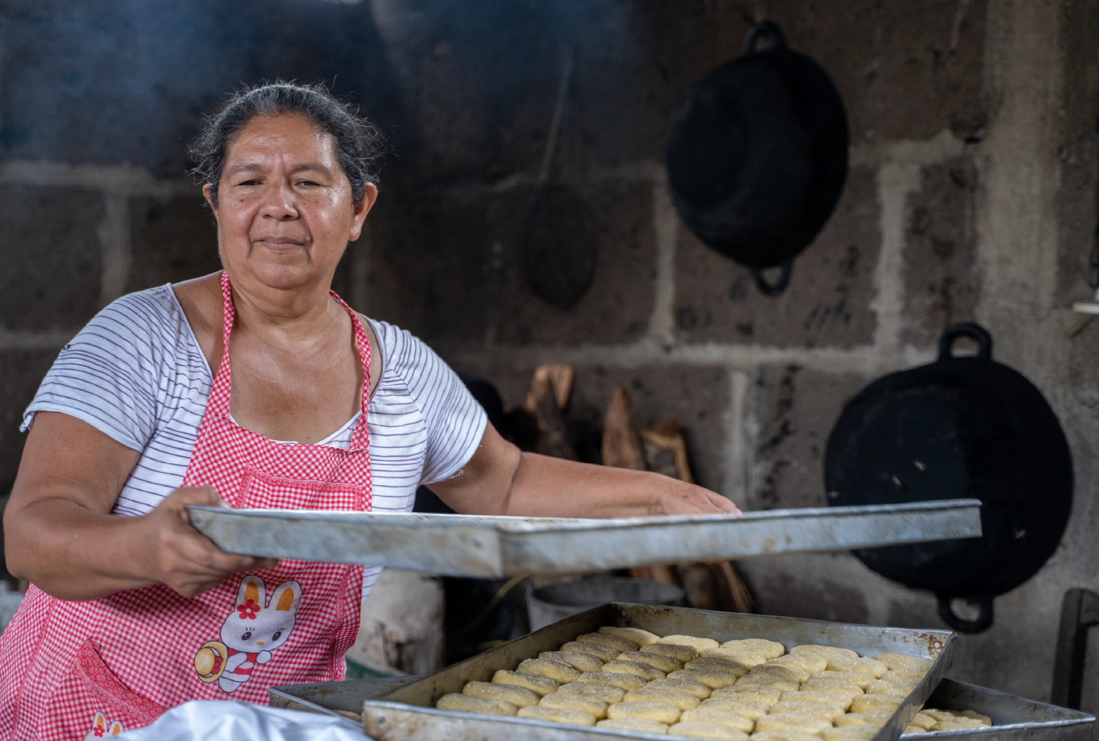Mujer preparando pan artesanal en un horno tradicional de leña