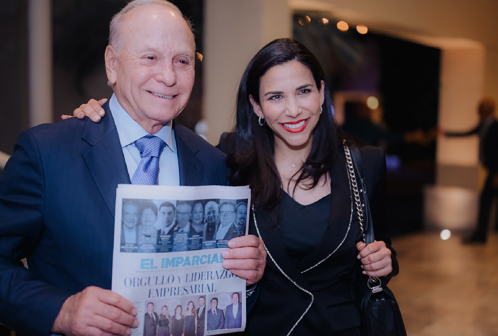 Javier Gándara Magaña sosteniendo un ejemplar de El Imparcial sobre liderazgo empresarial, junto a una mujer en un evento