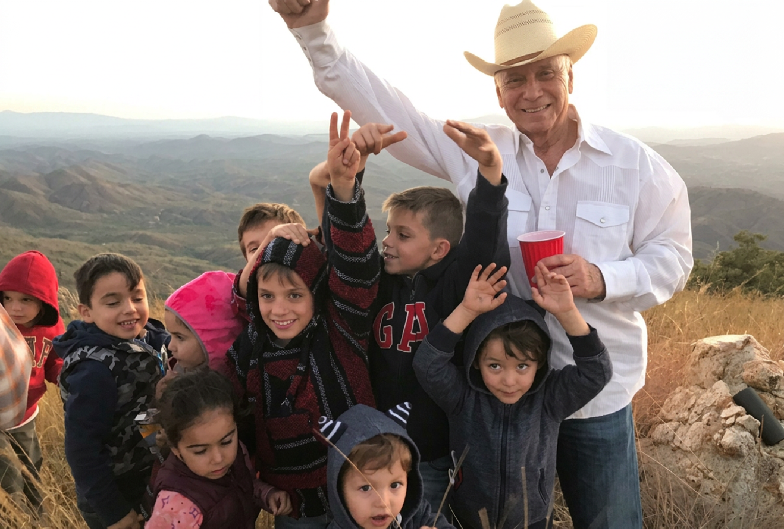 Javier Gándara Magaña conviviendo con un grupo de niños al aire libre en la sierra de Sonora